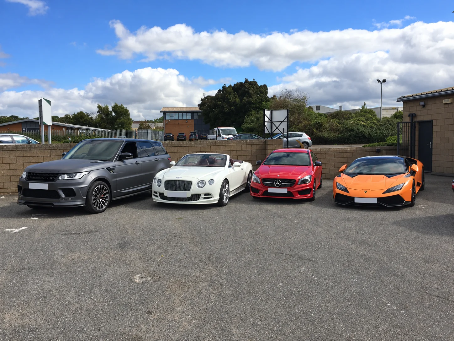 Range Rover, Bentley convertible, Mercedes and Lamborghini on a forecourt