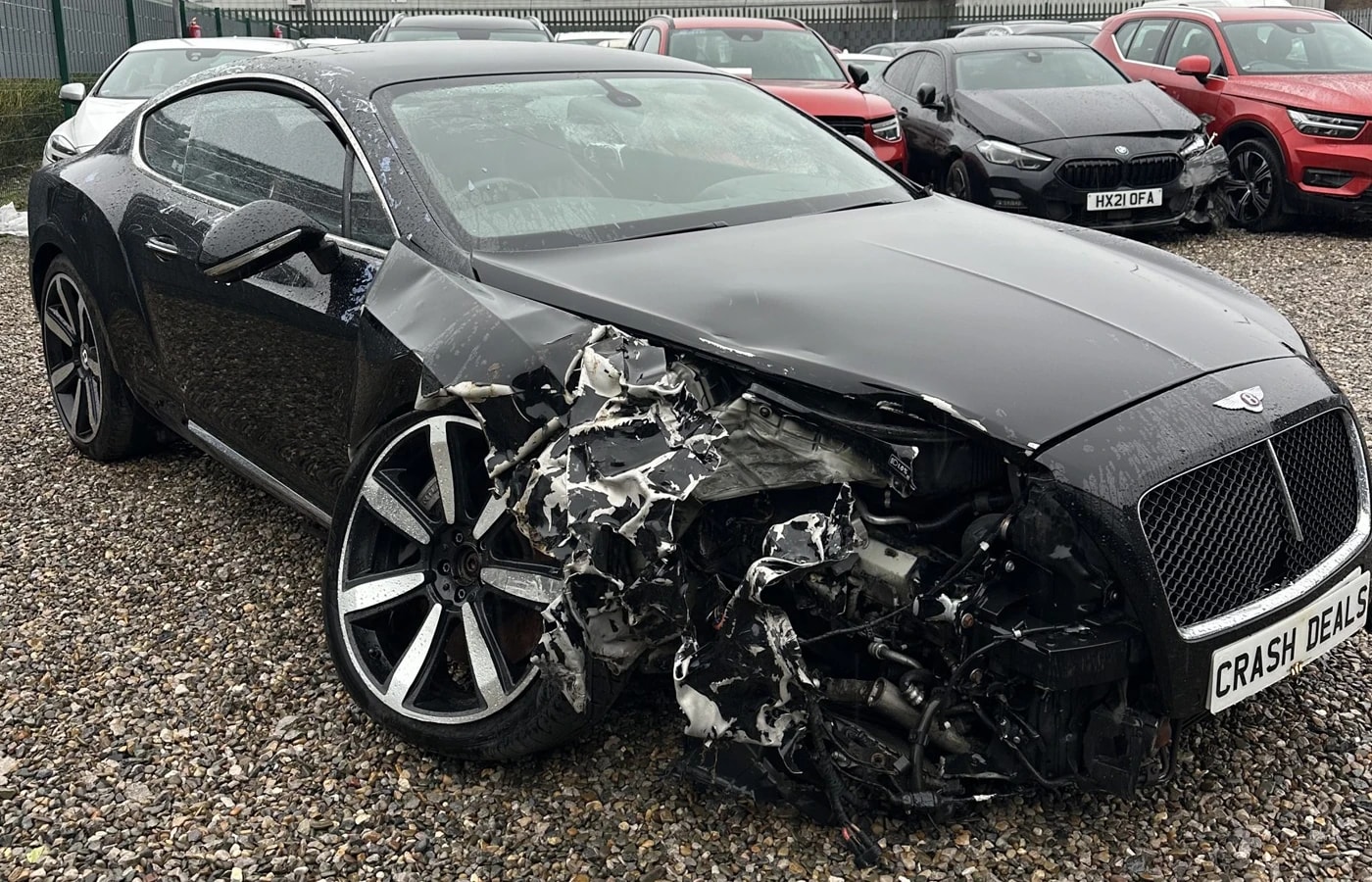 Damaged black Bentley Continental GT with front-end collision damage