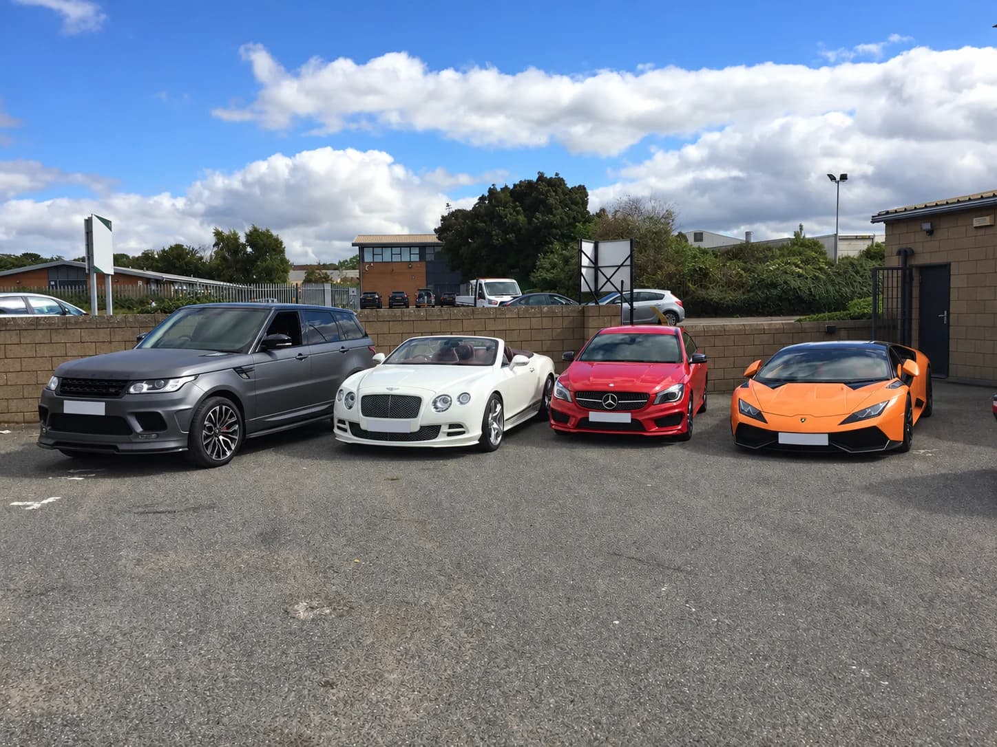 Range Rover, Bentley, Mercedes and Lamborghini parked in a row