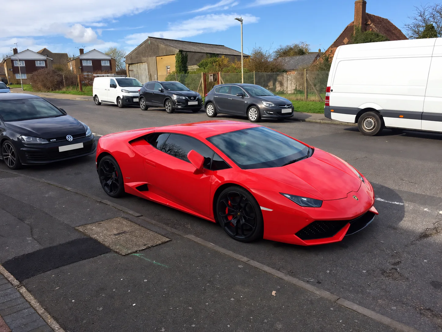Red Lamborghini parked on a residential street